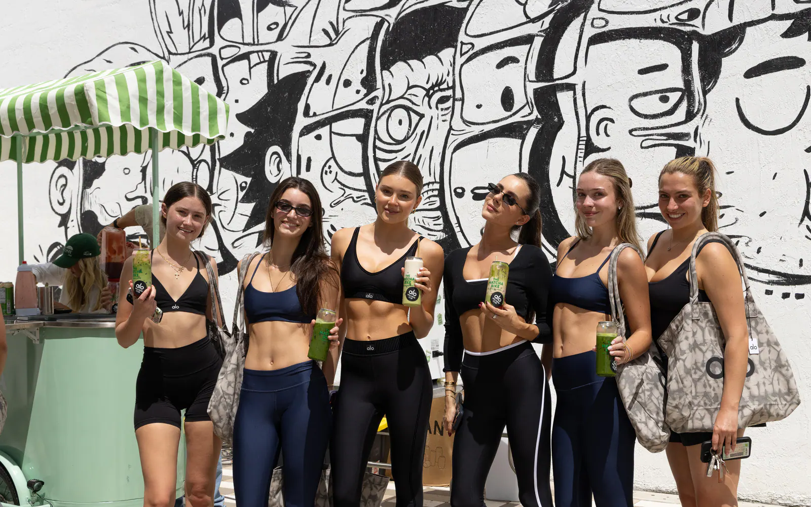 Guests with custom Matcha Bike cans at an Alo Wellness Club activation