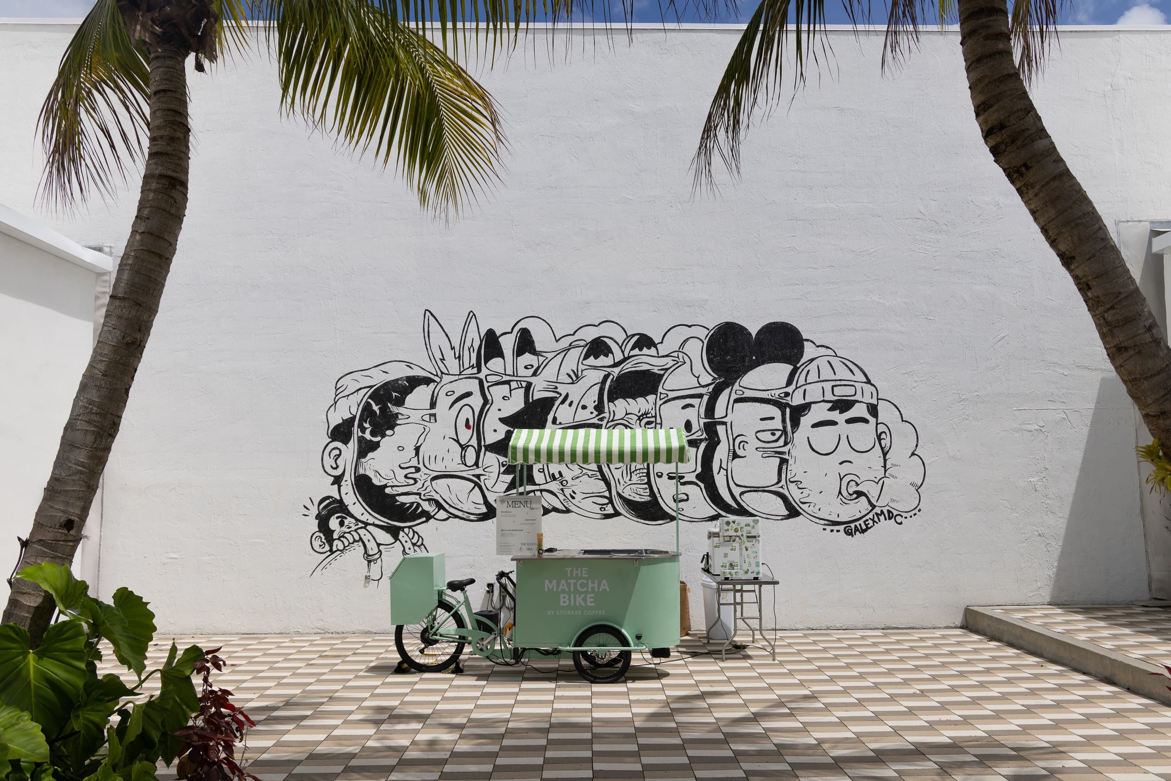 The Matcha Bike mint-green cart in a Miami courtyard under palm trees
